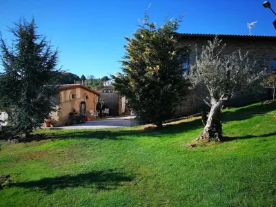 a green yard with two trees and a building at Alcázar Milmanda in Milmanda