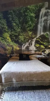 a bedroom with a waterfall mural on the wall at Alcázar Milmanda in Milmanda