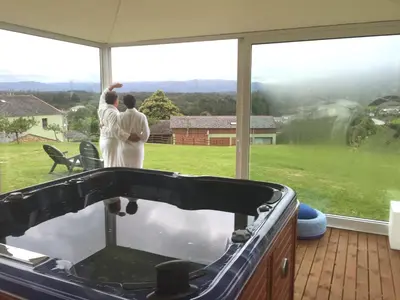 two people standing in front of a window looking out at a tub at Os Tres Teixos in San Acisclo