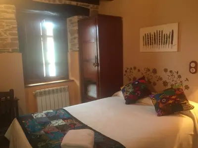 a bedroom with a bed and a window at Os Tres Teixos in San Acisclo