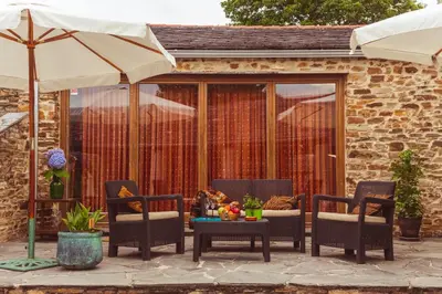 a patio with chairs and a table and an umbrella at Os Tres Teixos in San Acisclo