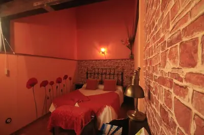 a bedroom with two beds and a brick wall at Os Tres Teixos in San Acisclo
