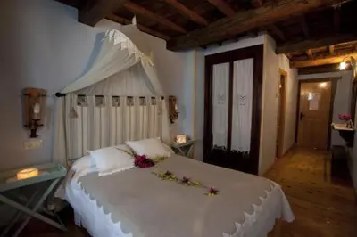 a bedroom with a large white bed with flowers on it at O Muiño de Pena in O Pino