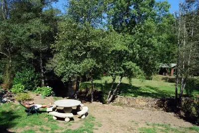 two people laying around a picnic table in the grass at O Muiño de Pena in O Pino
