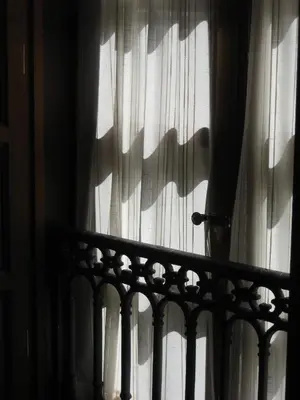 a shadow of a curtain on a window at Hotel Rolle in Ribadeo