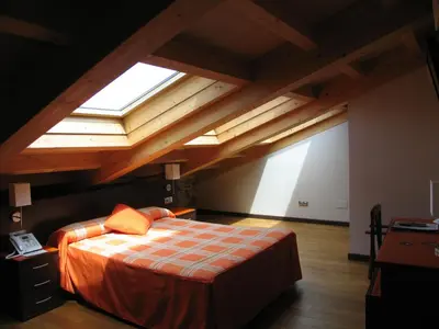 a bedroom with a large bed with a large window at Hotel Rolle in Ribadeo