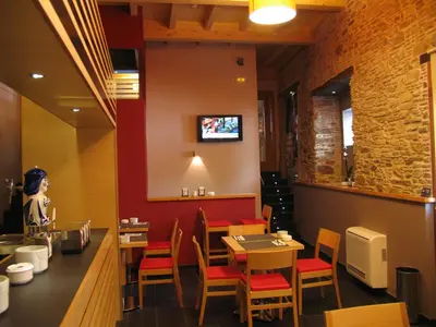 a restaurant with a table and chairs and a counter at Hotel Rolle in Ribadeo