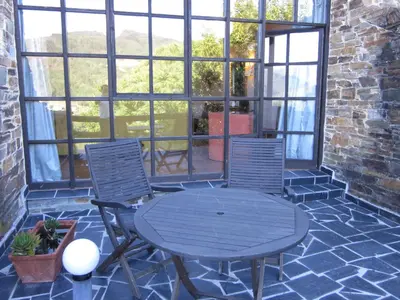 a patio with a table and two chairs at La Rectoral in Taramundi
