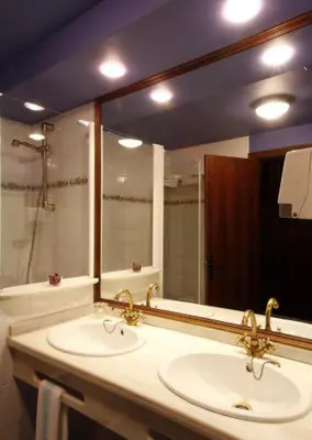 a bathroom with two sinks and a large mirror at La Rectoral in Taramundi