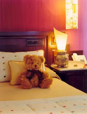 a teddy bear sitting on a bed with a lamp at La Rectoral in Taramundi