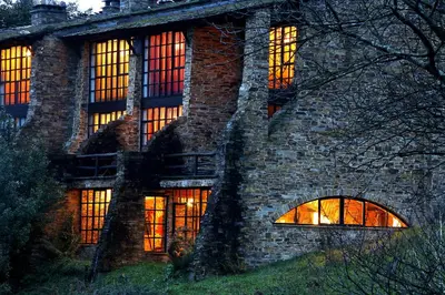 a stone building with windows with lights in it at La Rectoral in Taramundi