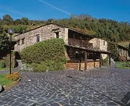a stone house with a brick walkway in front of it at La Rectoral in Taramundi