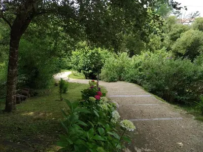 a path in a garden with flowers and trees at A Quinta Da Auga Hotel Spa Relais & Chateaux in Santiago de Compostela