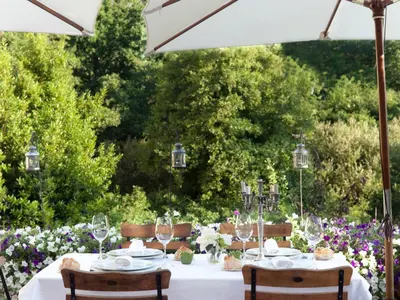 a table with a white table cloth and chairs and flowers at A Quinta Da Auga Hotel Spa Relais & Chateaux in Santiago de Compostela