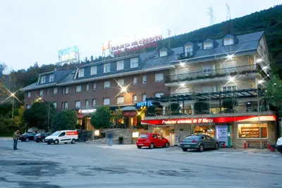 a large building with cars parked in a parking lot at Hotel Valcarce Camino de Santiago in La Portela de Valcarce