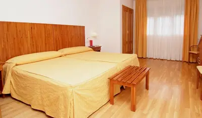 a bedroom with a large bed with a wooden headboard at Hotel Valcarce Camino de Santiago in La Portela de Valcarce