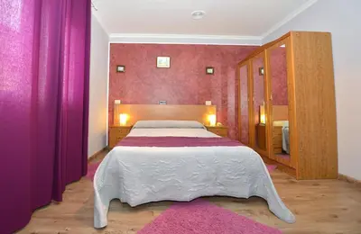 a bedroom with a large bed with pink walls at Santa Cruz in Ribadeo