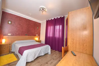a bedroom with a bed and purple curtains at Santa Cruz in Ribadeo