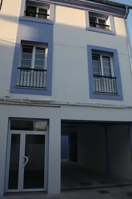 a white building with a door and windows at Santa Cruz in Ribadeo
