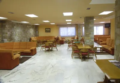 a waiting room with tables and chairs and a lobby at Hotel Scala in Padrón