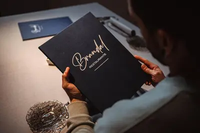 a woman holding up a book with the name at Hotel Scala in Padrón