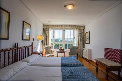 a bedroom with a large bed and a window at Pousada de Portomarín in Portomarin