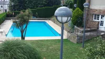 a blue swimming pool with a light pole next to it at Pousada de Portomarín in Portomarin