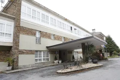 a large brick building with benches in front of it at Pousada de Portomarín in Portomarin