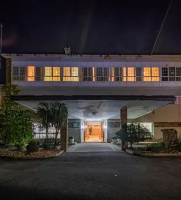 a large building with a walkway in the night at Pousada de Portomarín in Portomarin