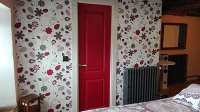 a red door in a room with a bedroom at Hotel Rural Casa Indie in Rabanal del Camino