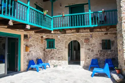 a group of blue chairs sitting on a patio at Hotel Rural Casa Indie in Rabanal del Camino