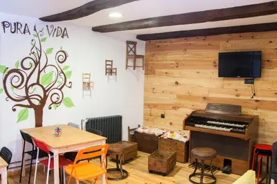 a room with a piano and a table and chairs at Hotel Rural Casa Indie in Rabanal del Camino