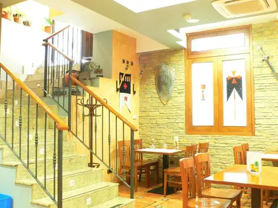 a restaurant with a staircase and a table and chairs at Hotel Los Templarios in Ponferrada