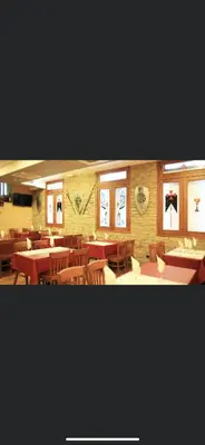 a restaurant with tables and chairs and pictures on the wall at Hotel Los Templarios in Ponferrada
