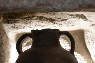a black vase with two handles in the dirt at Rectoral de Fofe in Fofe
