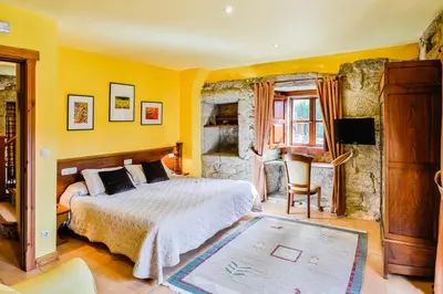 a bedroom with yellow walls and a bed and a desk at Rectoral de Fofe in Fofe