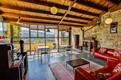 a living room with a red couch and a table at Rectoral de Fofe in Fofe