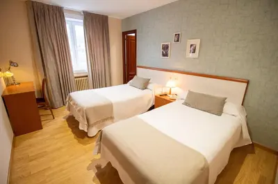 a hotel room with two beds and a window at Hotel Montero in Mondoñedo