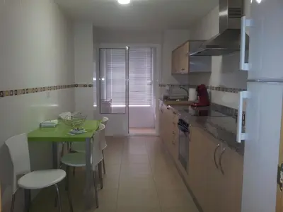 a kitchen with a small table and a green table at Apartamentos Antares 1 in Milladoiro