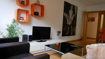 a living room with a flat screen tv on the wall at Apartamentos Antares 1 in Milladoiro