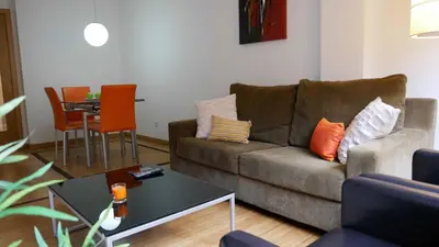 a living room with a couch and a table at Apartamentos Antares 1 in Milladoiro