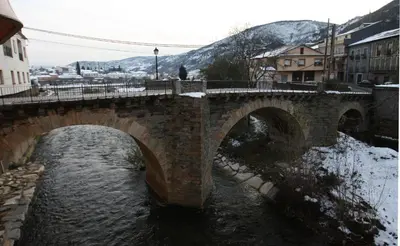 a stone bridge over a river in a city at Hostal Restaurante Méndez in Villafranca del Bierzo