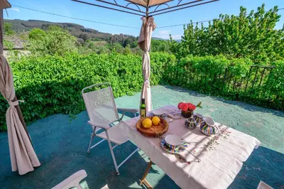 a picnic table with a basket of fruit and an umbrella at La Casa Antollosdocesar in Baralla
