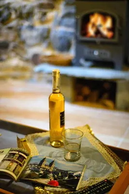 a bottle of oil on a table with a book and a glass at La Casa Antollosdocesar in Baralla