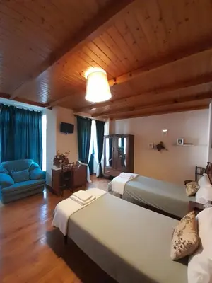 a bedroom with two beds and a blue couch at Casa Licerio in Samos
