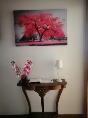 a painting of a red tree hanging on a wall at Casa Licerio in Samos