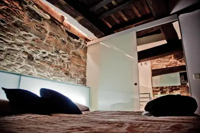 a bedroom with a bed and a brick wall at Posada Real La Pascasia in Puebla de Sanabria
