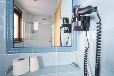 a bathroom with a blow dryer and a mirror at Hotel Alda Algalia in Santiago de Compostela