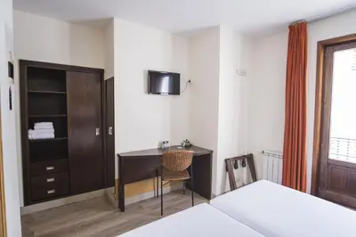 a hotel room with a desk and a bed at Hotel Alda Algalia in Santiago de Compostela