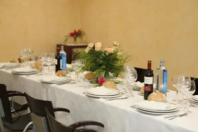a long white table with wine bottles and flowers on it at Hotel Santa Cruz in Montaos